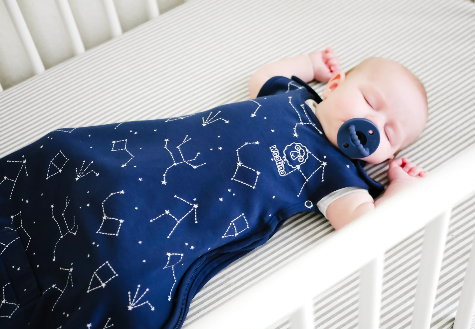 baby sleeping wearing woolino sleep sack nightsky